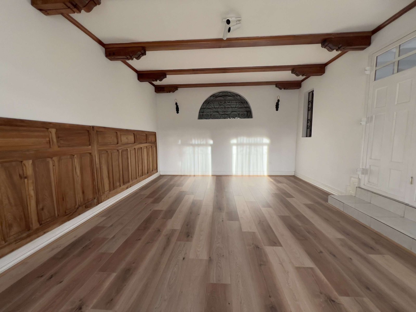 Sala grande con piso de madera y vigas